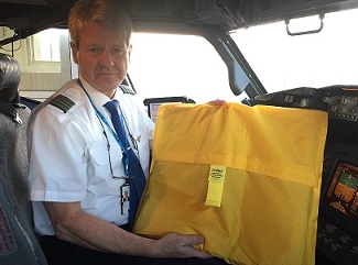 A pilot holding an AvSax fire containment bag