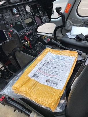 An AvSax lithium battery fire containment bag in its vacuum packing on a helicopter seat